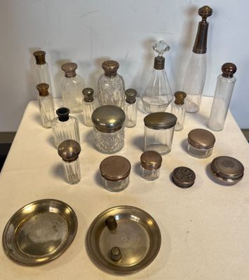 une table sur laquelle sont disposées de nombreuses bouteilles en verre et des couverts en argent