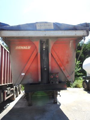 un gros camion-benne rouge garé à côté d'un camion blanc