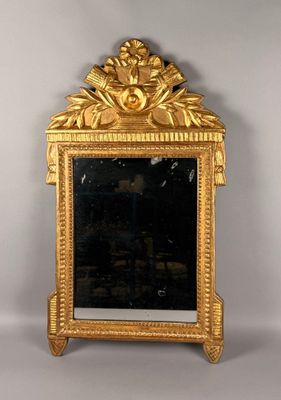 un miroir avec un cadre doré sur un mur blanc