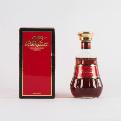 une bouteille de vin rouge posée à côté d'une boîte sur une surface blanche