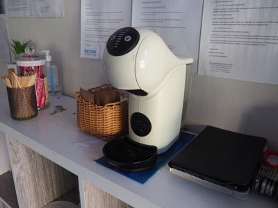une cafetière posée sur un plan de travail, à côté d'un ordinateur portable