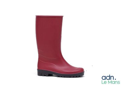 des bottes en caoutchouc rouges à semelles noires sur fond blanc