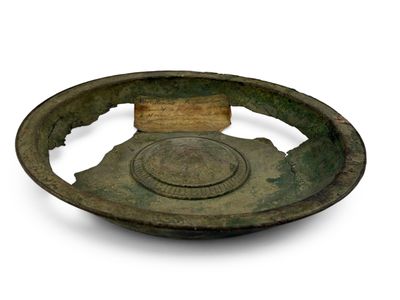 une vieille assiette en bronze ornée d'un motif circulaire