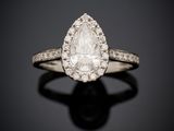 une bague sertie d'un diamant en forme de poire, avec des diamants sur un fond noir