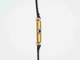 a close up of a black cord with a gold plated earphone attached to it