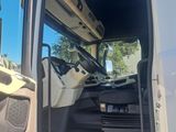 a white truck with the door open and the driver ' s seat down