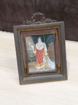 la photo d'une photo représentant un homme vêtu d'une robe rouge, posé sur une table
