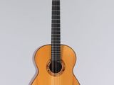 une image représentant une petite guitare acoustique sur fond blanc