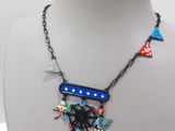 a necklace that has a spider on it on a mannequin
