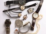 a lot of watches and bracelets on a white surface