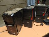 three computers sitting on a table with a keyboard and mouse