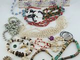a red box filled with lots of assorted beads and necklaces