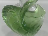 a green glass vase with a fish design on it