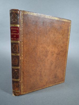 un livre ancien avec une couverture en cuir marron et des bordures dorées