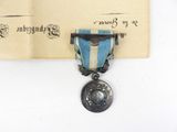 a medal with a blue ribbon and a silver medal on it