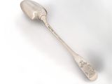 a silver spoon with a spoon handle on a white surface