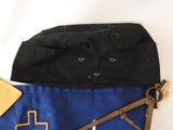 a blue bag with a cross on it next to a pair of scissors
