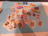 many different stamps on a blue piece of paper on a table