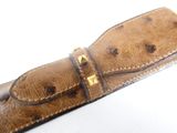 brown ostrich leather belt with gold studs on a white background