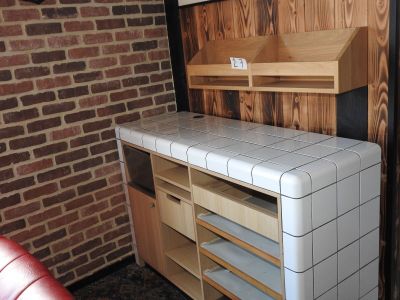 une cuisine avec un mur en briques et un plan de travail en carrelage blanc