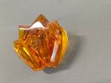 an orange glass object sitting on a table next to a pair of scissors