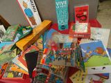 de nombreux livres pour enfants posés sur une table recouverte d'une nappe rouge