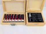two wooden boxes with tools in them on a white surface