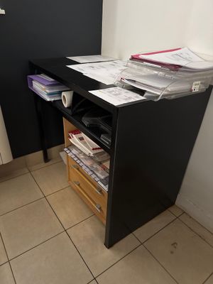 a black desk with a drawer full of files