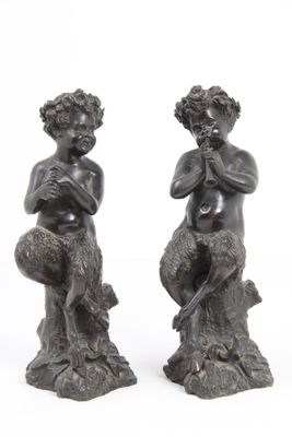 deux statues représentant un homme et une femme assis sur une souche d'arbre
