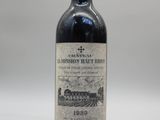 une bouteille de vin rouge posée sur une table blanche
