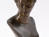 bronze bust of a woman with curly hair and a flower in her hair