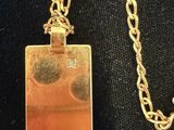 a gold necklace with a square shaped pendant on a chain