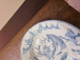 a blue and white plate sitting on a wooden table