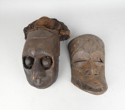 two wooden masks are sitting next to each other on a white surface