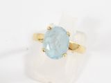 a gold ring with a blue topaz stone in it