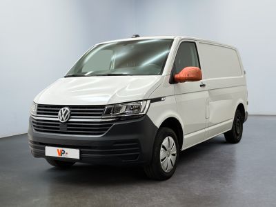 La camionnette blanche est garée dans une pièce au sol noir
