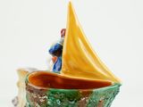 a small boat with a man on it sitting in a bowl