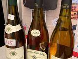 trois bouteilles de vin posées sur une table, l'une à côté de l'autre