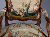 an old chair with a floral upholstered back and a floral upholstered seat