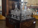 bottles and glasses in a wooden box on a table in a room
