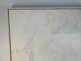 une photo d'un tableau accroché à un mur blanc