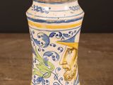 a blue and yellow vase sitting on a wooden table