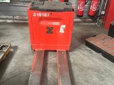 un chariot élévateur sur lequel se trouve une caisse rouge, dans un garage