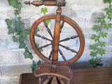 a spinning wheel on a wooden table in front of a brick wall
