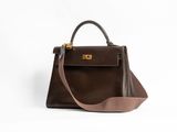 un sac à main marron sur fond blanc, muni d'une bandoulière marron