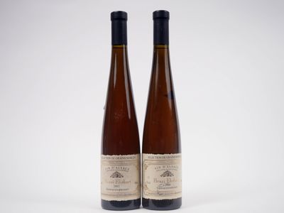 deux bouteilles de vin posées l'une à côté de l'autre sur une surface blanche