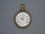 une montre de poche en or avec des chiffres romains sur le cadran