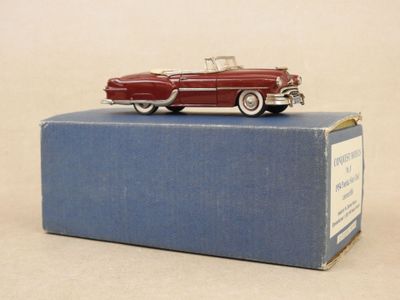 une petite voiture rouge posée sur une boîte bleue