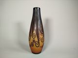 a brown and black vase with swirl designs on it