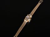 a gold watch on a black background